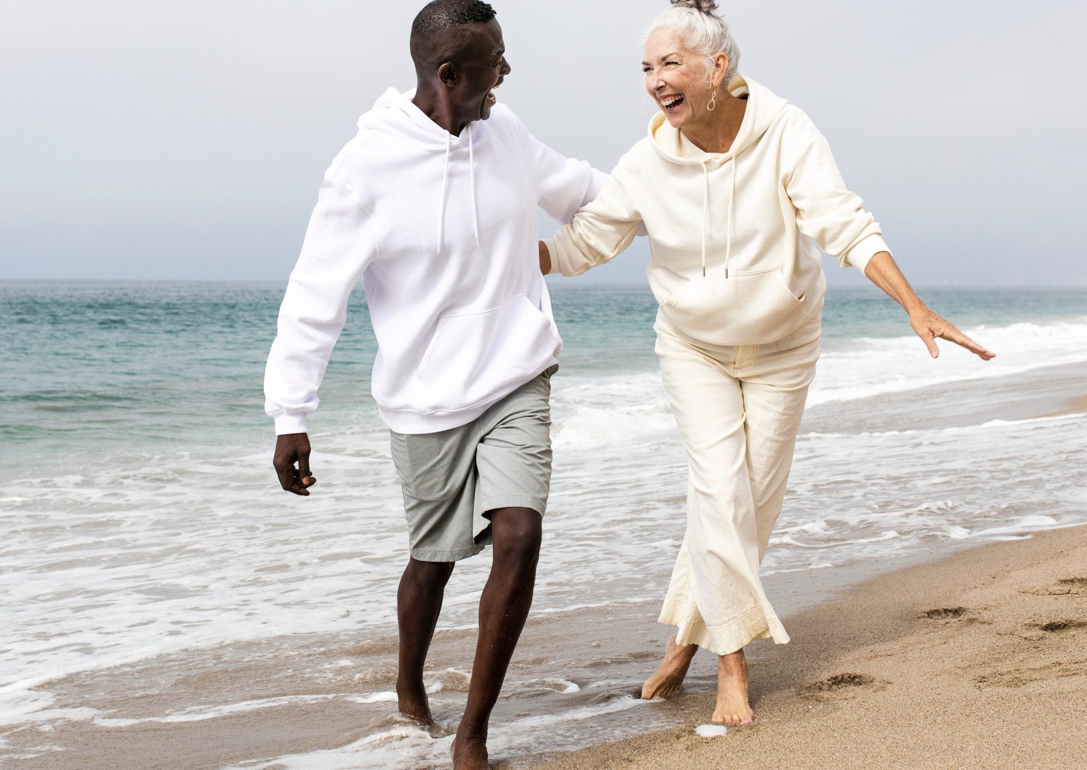 Older couple at the beach together are walking through the coast line